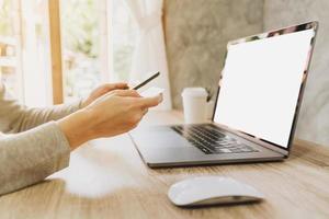 woman using smart phone and credit card for shopping online in coffee shop photo