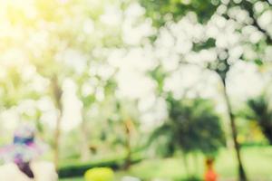 defocused bokeh and blur background of garden trees in sunlight with vintage toned. photo