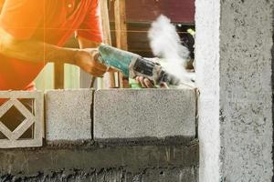 Man worker electric drill make cement pole structure of home photo