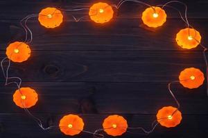 fondo de halloween, luces de cadena de calabaza en la mesa de madera foto
