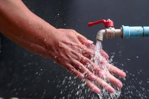 person washing hands in water photo