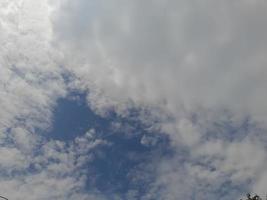 Beautiful white clouds on deep blue sky background. Large bright soft fluffy clouds are cover the entire blue sky. photo