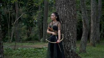 Indonesian women shooting an arrow from the bow to the enemy she haunted in the jungle video