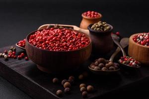 Composition, concept, consisting of several types of different colors of allspice in bowls and spoons photo