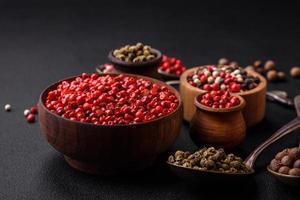 Composition, concept, consisting of several types of different colors of allspice in bowls and spoons photo