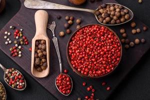 Composition, concept, consisting of several types of different colors of allspice in bowls and spoons photo