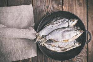 carnero de pescado en una sartén redonda de hierro fundido negro foto