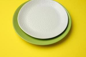 empty round white plate for main courses on a yellow background photo
