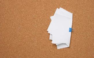 white blank paper sheets bound with a clip on brown background photo