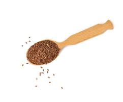 brown dry flax seeds in a wooden spoon on a white background photo