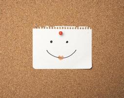 paper sheet with joyful emotion attached by button on brown board photo