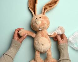 soft plush rabbit with a bandaged paw with a white medical bandage photo
