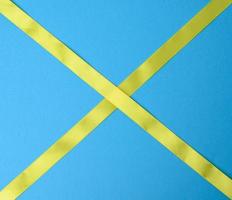 yellow silk ribbon on a blue background photo