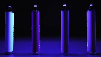 veel van e-sigaretten en vapen in neon verlichting en rook. concept van slecht gebruiken. modern alternatief naar tabak producten. nicotine verslaving. langzaam beweging. video