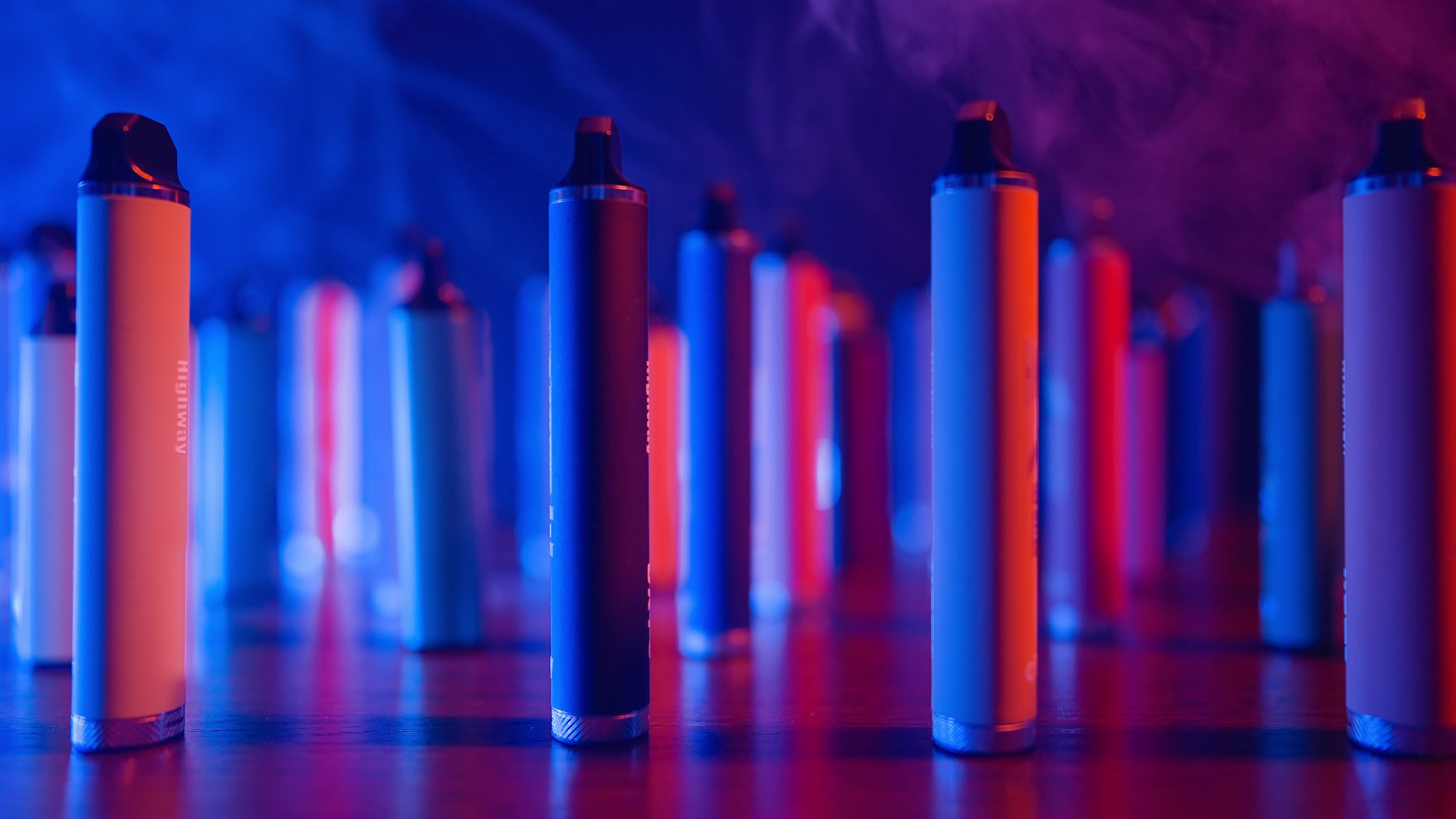 Lots of Ecigarettes and Vapes in Neon Lighting and Smoke. Concept of