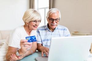 Senior Couple Using Laptop To Shop Online. Elderly couple paying bills online on laptop photo