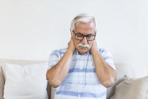 Senior man feeling exhausted and suffering from neck pain, Health concept. Sad senior man with neckache. Elderly man with chronic pain syndrome fibromyalgia suffering from acute neckaches. photo