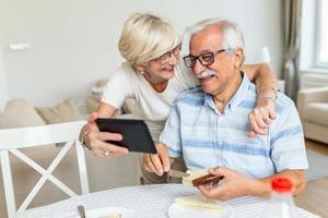 pareja senior tomando un selfie con tableta. pareja de ancianos que tiene una videollamada con amigos o familiares usando una tableta. la pareja de ancianos está hablando en línea a través de una conexión de video en la tableta. foto