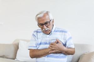 Senior man suffering chest pain, heart attack, problems with breathing, asthma. Elderly man having problems with angina pectoris photo