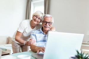 cónyuges ancianos en el hogar. la esposa abraza al esposo. tener una conversación agradable charlando con hijos y nietos adultos usando el concepto de tecnología inalámbrica foto