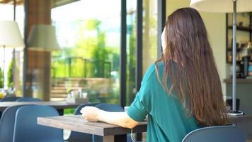 Woman in cafe drinking coffee listening the music. video