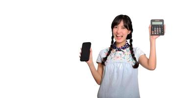 retrato de una hermosa joven asiática vestida de mezclilla con calculadora y teléfono inteligente con fondo blanco. concepto de compras en línea de negocios. foto