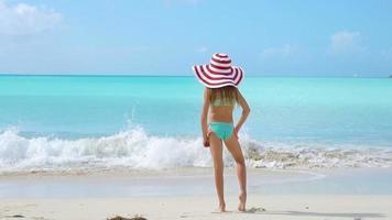 adorable niña con sombrero grande en la playa video