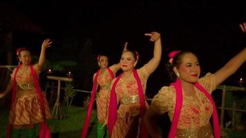 balinese persone danza insieme a tradizionale danza concorsi con contento facce mentre indossare verde calzini e rosso sciarpa su il palcoscenico video