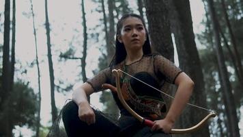 vrouw boogschieten Holding een boog en een pijl in de oerwoud jacht- voor vijand video