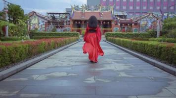 une magnifique chinois femme fonctionnement dans le rouge costume à l'intérieur le jardin video