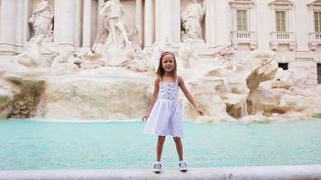 adorable niña fondo fuente de trevi, roma, italia. feliz niño toodler disfruta de vacaciones italianas en europa. video