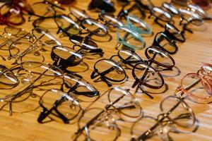 large selection of sunglasses and glasses on a stand photo