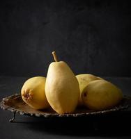 ripe green pears on a metal plate, black background photo