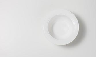 empty white round ceramic soup plate on white table, top view photo