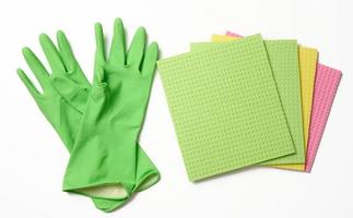 green rug, rubber gloves for cleaning on a white background, flat lay. photo