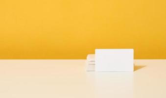 stack of white rectangular business cards on a yellow background, company branding, address. photo