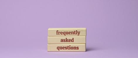 inscription frequently asked questions on wooden blocks on a purple background photo