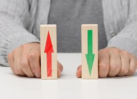 female hand holds wooden blocks with up and down arrows. The concept of lowering and increasing indices, exchange rates. Dynamics photo