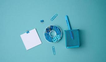 stack of white square sheets of paper for notes, stationery on blue background, top view photo