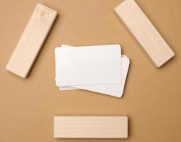 stack of white rectangular business cards on a brown background, company branding, address. View from above, flat lay photo