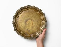 female hand holding empty copper round vintage plate on white background, fruit dish photo