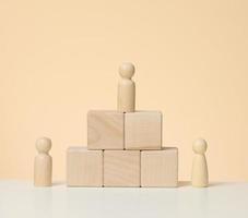 wooden figures of men stand on a pedestal of their cubes. The concept of rivalry in sports, business and life photo