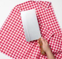 female hand holding a large sharp kitchen knife for cutting meat on a white background photo