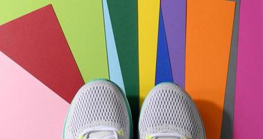 white women's sneakers with laces on a color background, top view photo