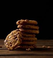 apilar de horneado redondo galletas en un de madera mesa, negro antecedentes foto