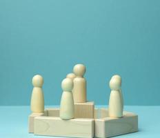 wooden figurines of men on a blue background. Public speaking concept, leadership and discussion photo