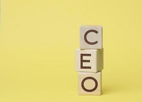 CEO inscription on wooden cubes, yellow background photo