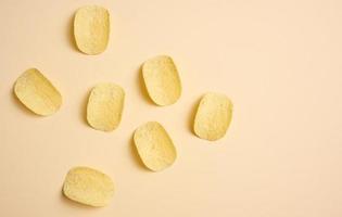 round potato chips on a beige background, top view photo