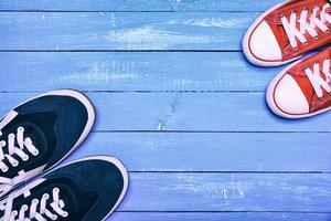 Two pairs of sporting sneakers, blue men's sneakers and red women's photo