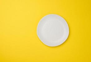 empty white plate on white yellow background, top view photo